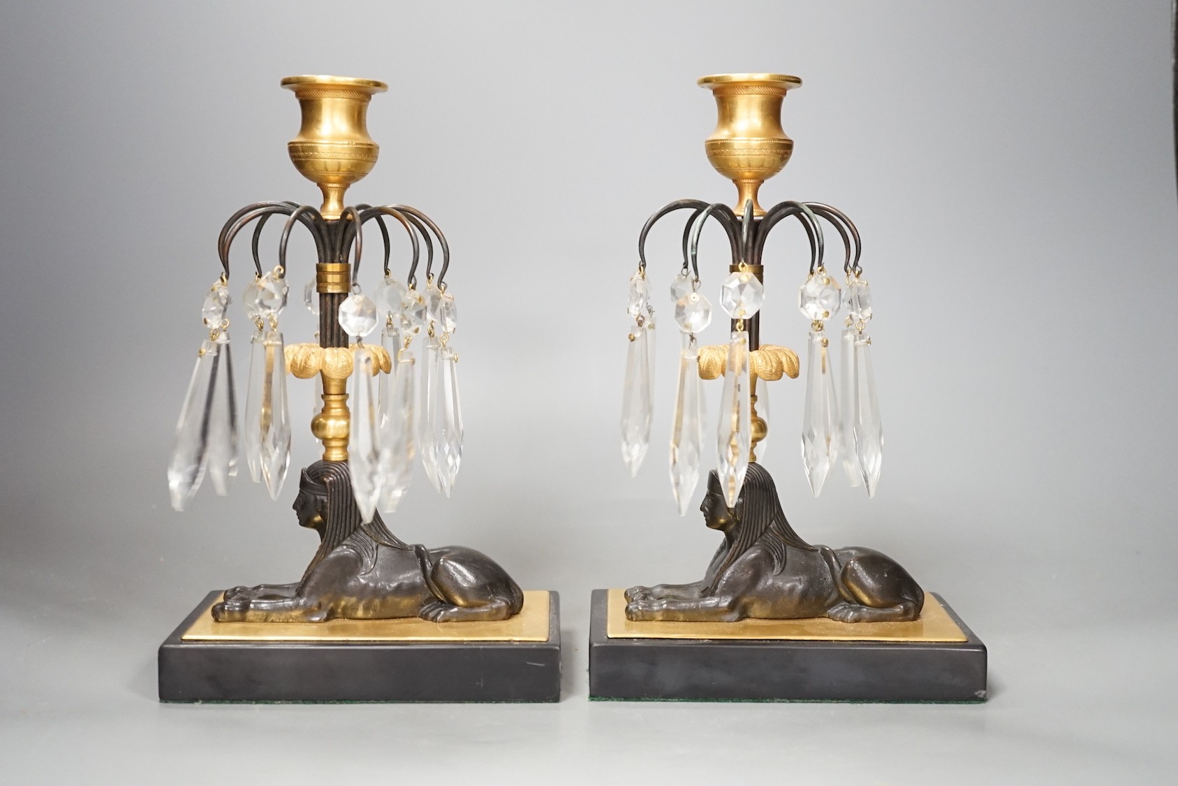 A pair of lustre drop 'sphinx' candlesticks - 23cm tall
